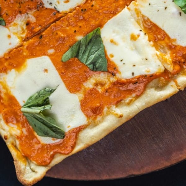 Close-up of a Bacco Centro Italian pizza with red sauce, melted mozzarella, and fresh basil.