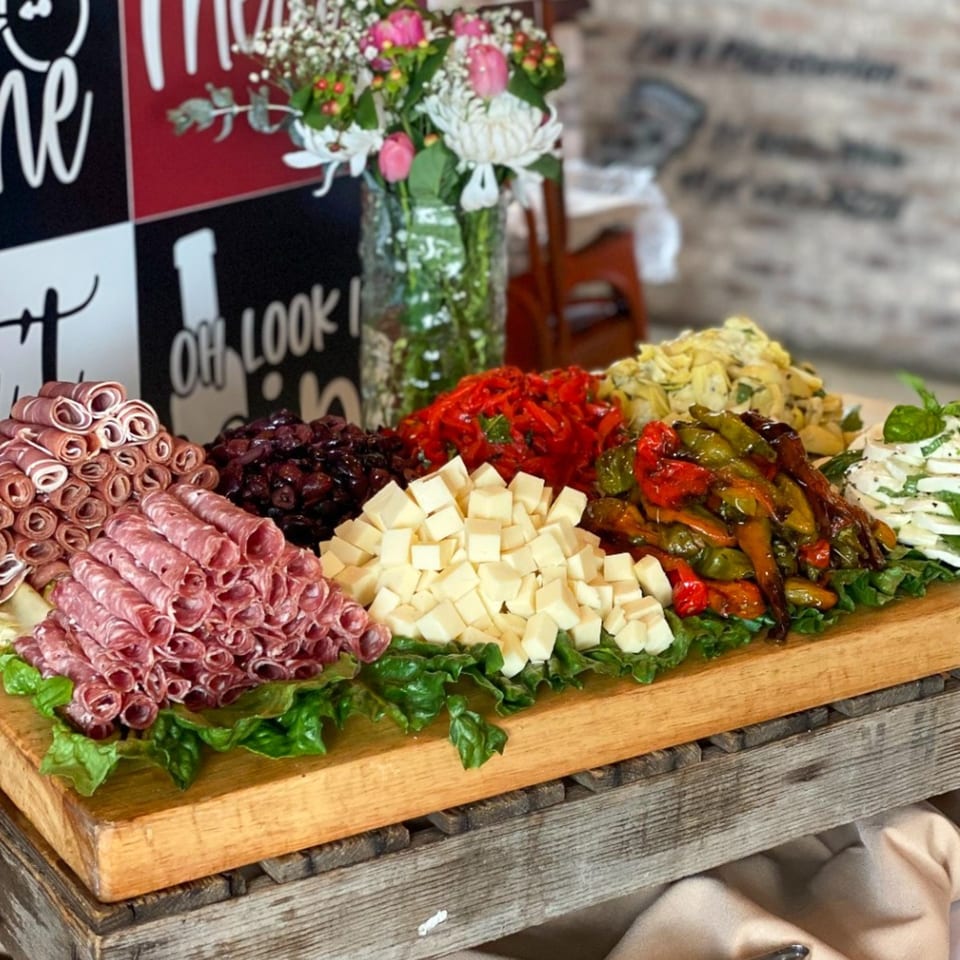 A Bacco Centro Italian charcuterie board with meats, cheeses, roasted peppers, and olives.
